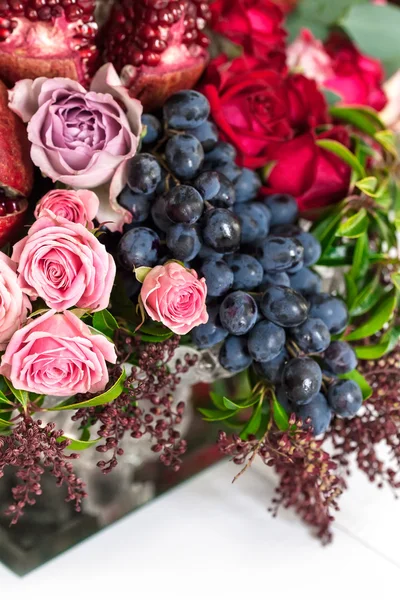 Un bouquet di rose rosse e rosa, peonie con uva e melograno primo piano — Foto Stock