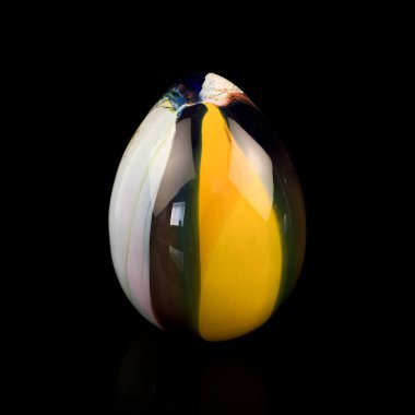 glass antique egg on a black background. glass Easter egg with colored marble stains