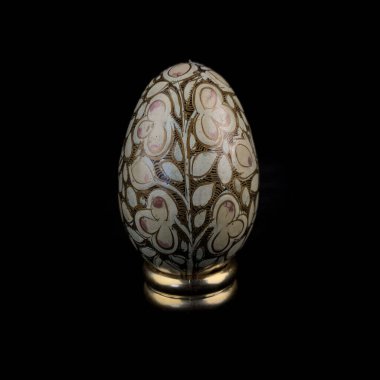 wooden Easter egg with floral patterns on isolated black background