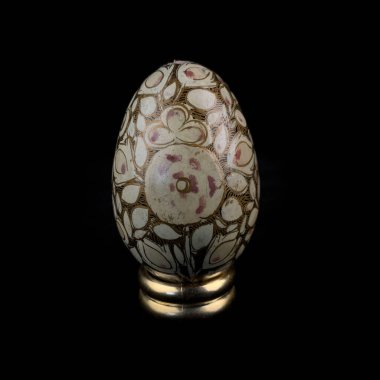 wooden Easter egg with floral patterns on isolated black background