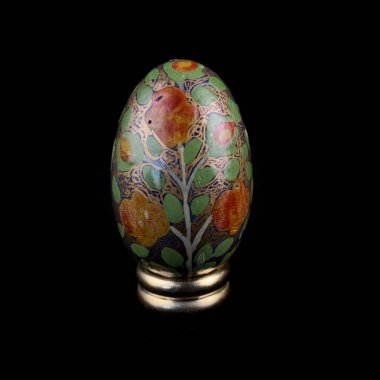 wooden Easter egg with floral patterns on isolated black background