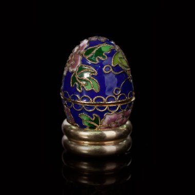 Metalik paskalya yumurtası, izole edilmiş siyah arka planda elle boyanmış desenler. Faberge yumurtası.