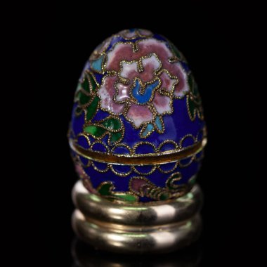 Metalik paskalya yumurtası, izole edilmiş siyah arka planda elle boyanmış desenler. Faberge yumurtası.