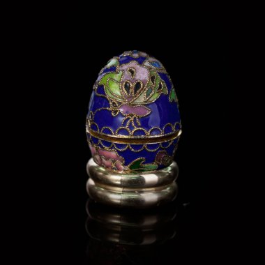 Metalik paskalya yumurtası, izole edilmiş siyah arka planda elle boyanmış desenler. Faberge yumurtası.