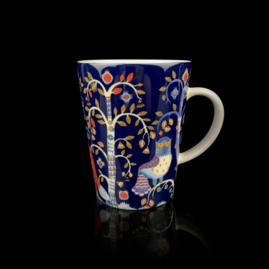 Ormanın görüntüsü olan retro bardak. Eski mavi bardakta desenler. Siyah arka planda çay fincanı
