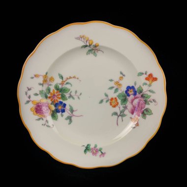 antique plate with a picture of flowers. vintage plate with painting on black isolated background