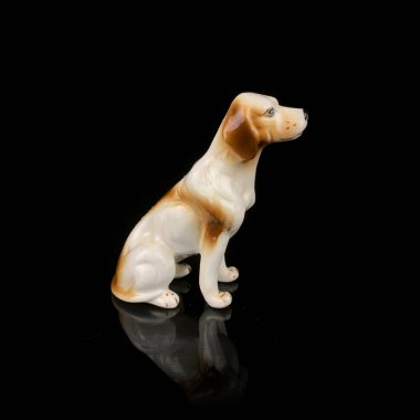 Köpek şeklinde antik bir porselen heykel. Siyah izole edilmiş arka planda zencefilli köpeğin antika biblosu