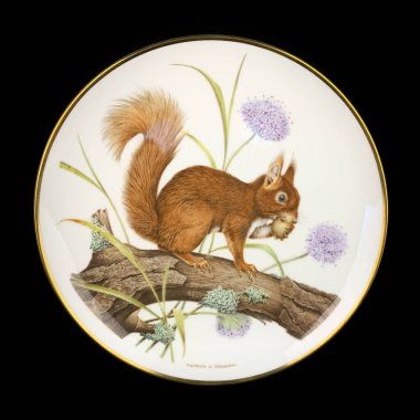 antique ceramic plate with the image of animals. plate on black background