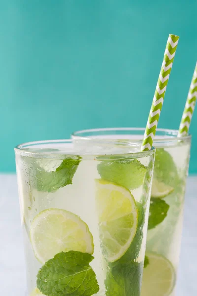 Sommergetränk. frischer Mojito mit Limette und Minze. blauer Hintergrund — Stockfoto