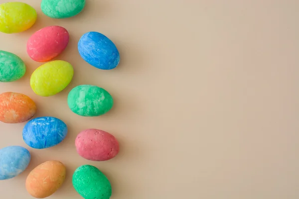 Цветные пасхальные яйца на бежевом фоне — стоковое фото