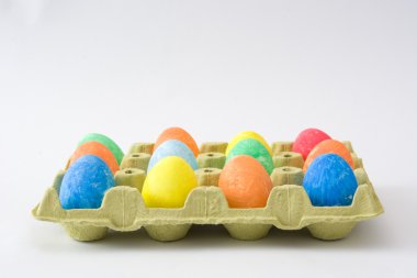 Bir karton beyaz arka plan üzerinde renkli boyalı yumurta