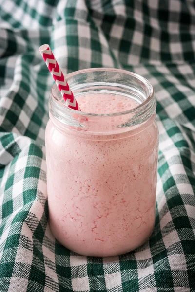 Erdbeer-Smoothie auf einer grünen Tischdecke — Stockfoto