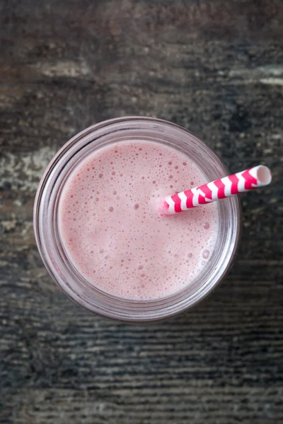 Delicioso batido de fresa sobre madera rústica —  Fotos de Stock