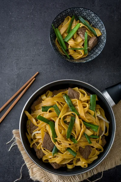 Čínské jídlo. Hovězí chow mein. Černý kámen pozadí — Stock fotografie