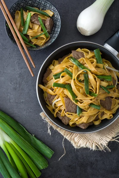 Chinese food. Beef chow mein. Black stone background — Stock Photo, Image
