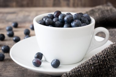 Bir fincan kahverengi kumaş üzerinde yaban mersini