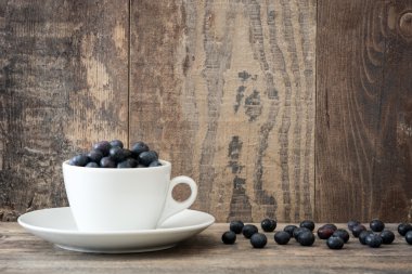 Ahşap üzerine bir bardak yaban mersini