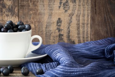 Ahşap üzerine bir bardak yaban mersini