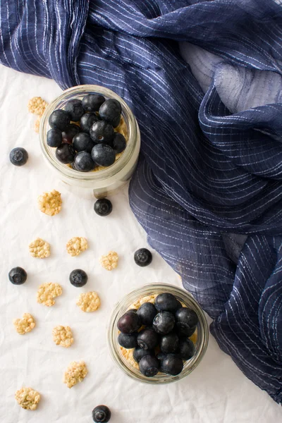 Yoghurt med blåbär på vitt bord — Stockfoto