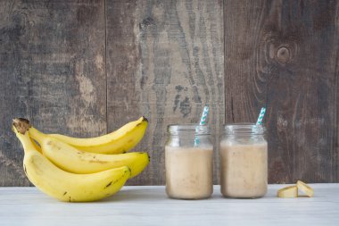 Beyaz ahşap üzerine muz smoothie