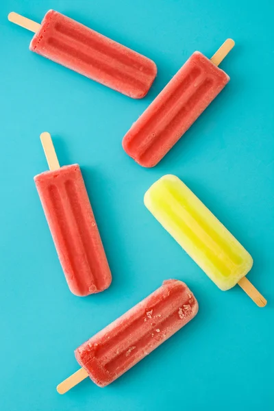 Popsicles aux fraises et au citron sur fond bleu — Photo