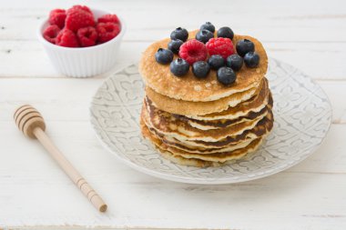 Yaban mersini ve ahududu ahşap beyaz üzerinde gözleme