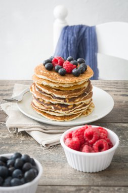 Yaban mersini ve rustik ahşap ahududu ile Pancakes