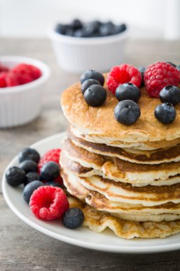 Yaban mersini ve rustik ahşap ahududu ile Pancakes