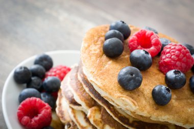 Yaban mersini ve rustik ahşap ahududu ile Pancakes
