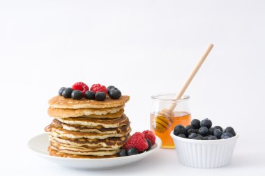 Yaban mersini ve beyaz arka plan üzerinde izole ahududu ile Pancakes