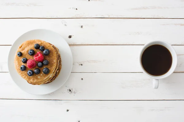 Pancakes with blueberries and raspberries on white wood — Stock Photo, Image