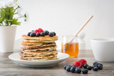 Yaban mersini ve rustik ahşap ahududu ile Pancakes