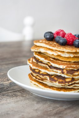 Yaban mersini ve rustik ahşap ahududu ile Pancakes