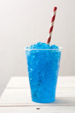 Blue summer slushie on white wooden table clipart