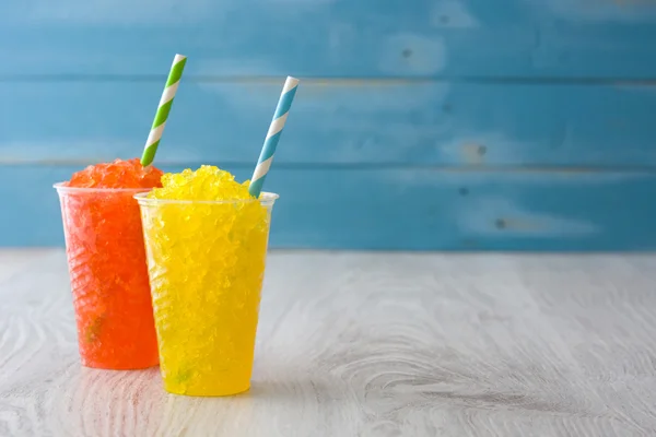 Mavi ahşap arka plan üzerinde renkli yaz slushies