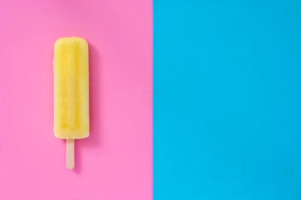 Zitrone Eis am Stiel auf rosa und blauen Hintergrund — Stockfoto