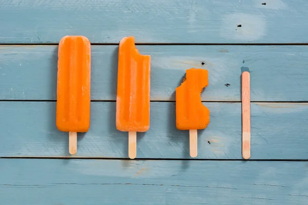 Pomarańczowy popsicles na niebieski drewniane — Zdjęcie stockowe