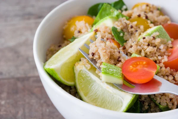 Quinoa, tomatoes and spinach on rustic  wooden table — Stock Photo, Image