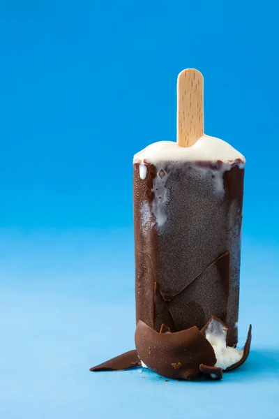 Chocolate popsicle on blue background — Stock Photo, Image