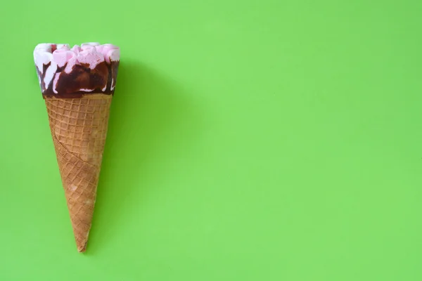 Strawberry ice cream cone on green background — Stock Photo, Image