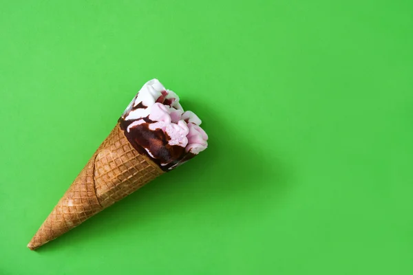 Strawberry ice cream cone on green background — Stock Photo, Image