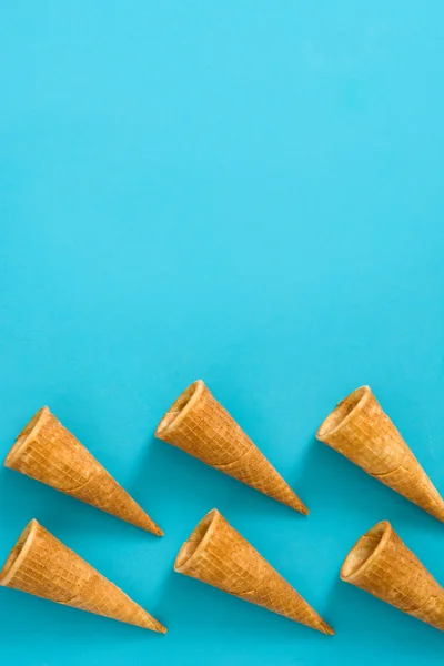 Cornets de crème glacée vides sur fond bleu — Photo