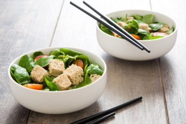 Vejetaryen tofu salata domates ve kuzu 's marul bir rustik ahşap tablo