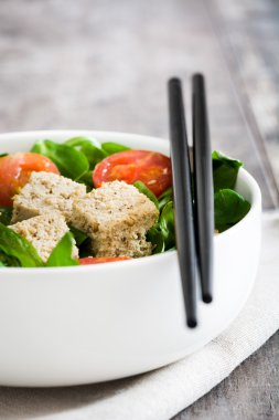 Vejetaryen tofu salata domates ve kuzu 's marul rustik ahşap zemin üzerine