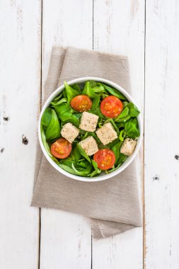 Vejetaryen tofu salata domates ve kuzu 's marul Beyaz ahşap zemin üzerinde