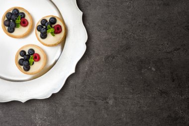 Ahududu ve yaban mersini bir tepsi ile lezzetli tartlets.