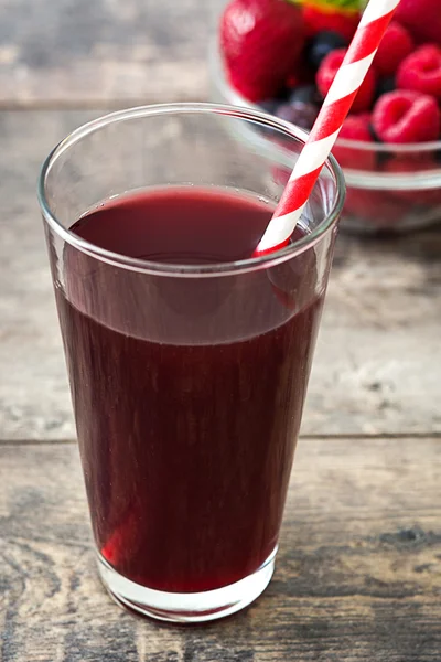 Красный фруктовый коктейль в стакане на дереве — стоковое фото