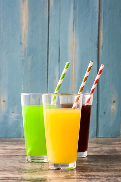 Fresh fruit smoothies on rustic wooden floor and blue wooden wall — Stock Photo, Image