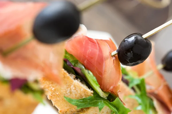 Испанский шашлык из ветчины серрано с оливковым и салатом — стоковое фото