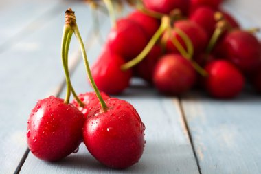 Mavi ahşap bir masa üzerinde lezzetli kiraz